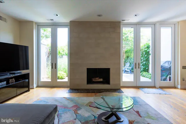 a living room with furniture a flat screen tv and a fireplace
