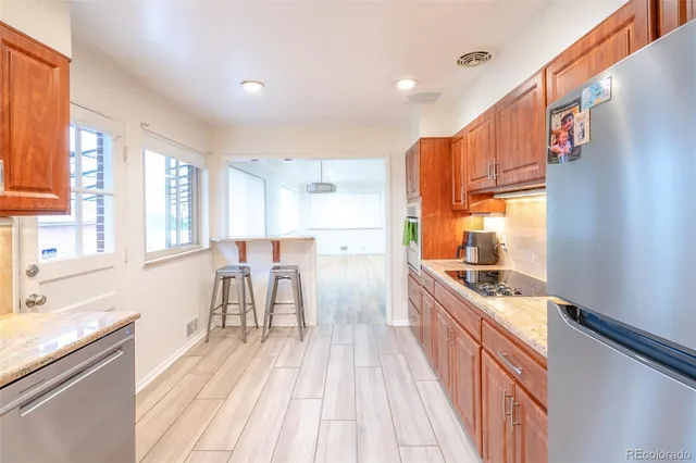 a kitchen with kitchen island granite countertop lots of counter top space and wooden floor