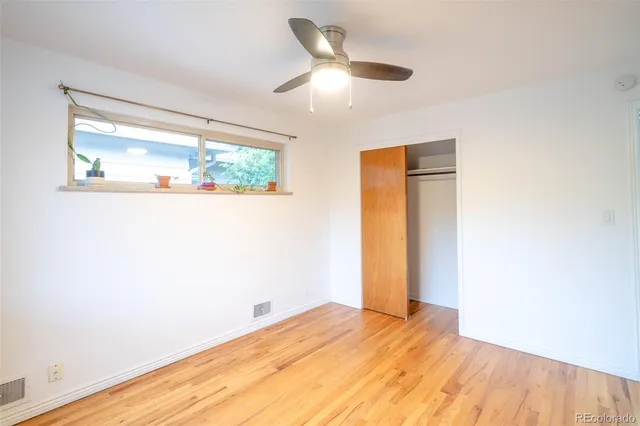 a view of empty room with wooden floor