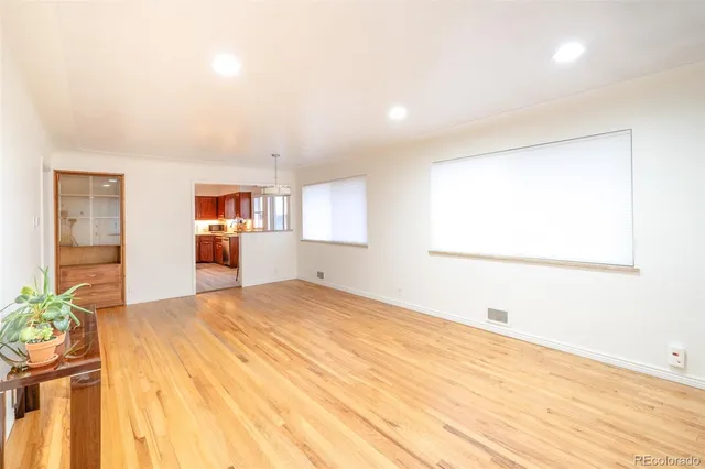 a big room with wooden floor and windows