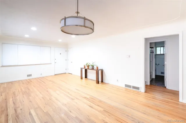 a view of empty room with wooden floor