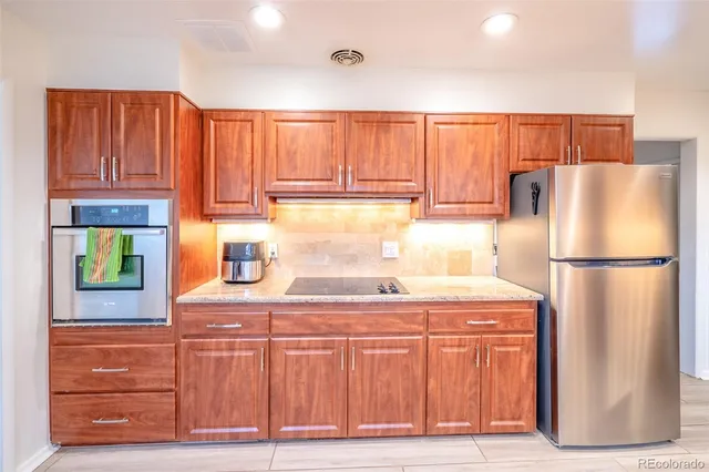 a kitchen with stainless steel appliances granite countertop a refrigerator and a stove