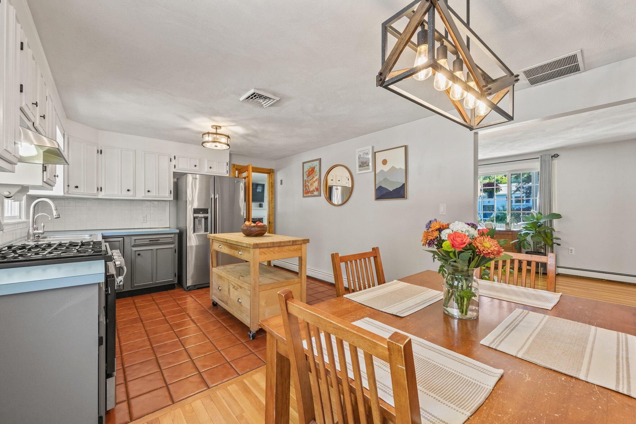 39 Maddaket Lane Centerville, MA 02632 - Photo 14 of 36 a kitchen with stainless steel appliances granite countertop a sink a stove a dining table and chairs with wooden floor