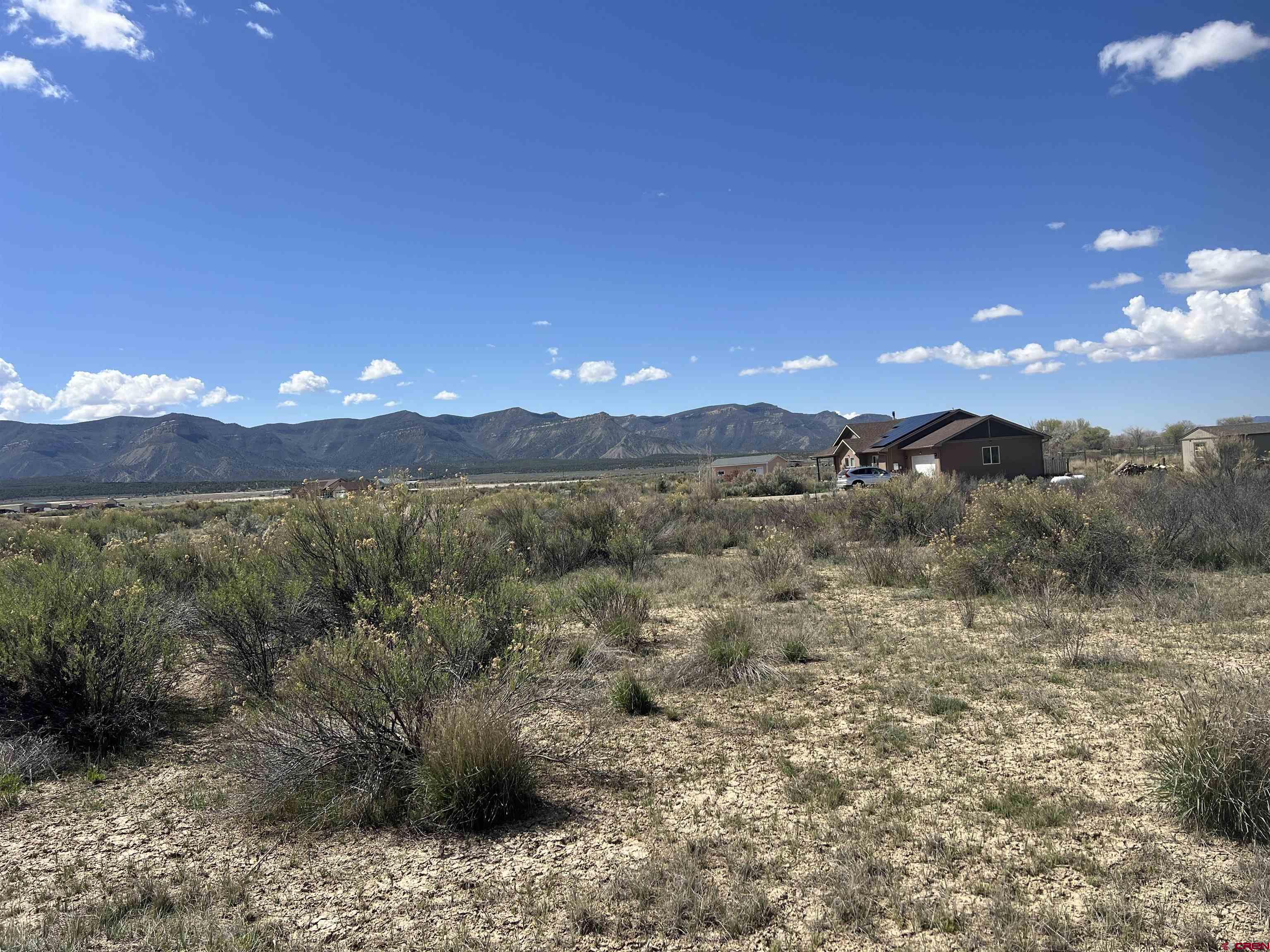 8385 Road 29.4 Loop Cortez, CO 81321 - Photo 4 of 8 a view of a dry yard with mountains in the background