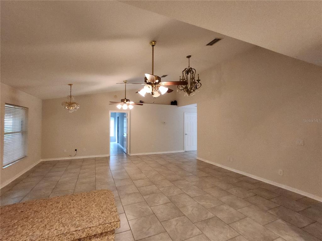 6521 East Grayson Street Inverness, FL 34452 - Photo 7 of 16 a view of a room with a chandelier fan and kitchen view