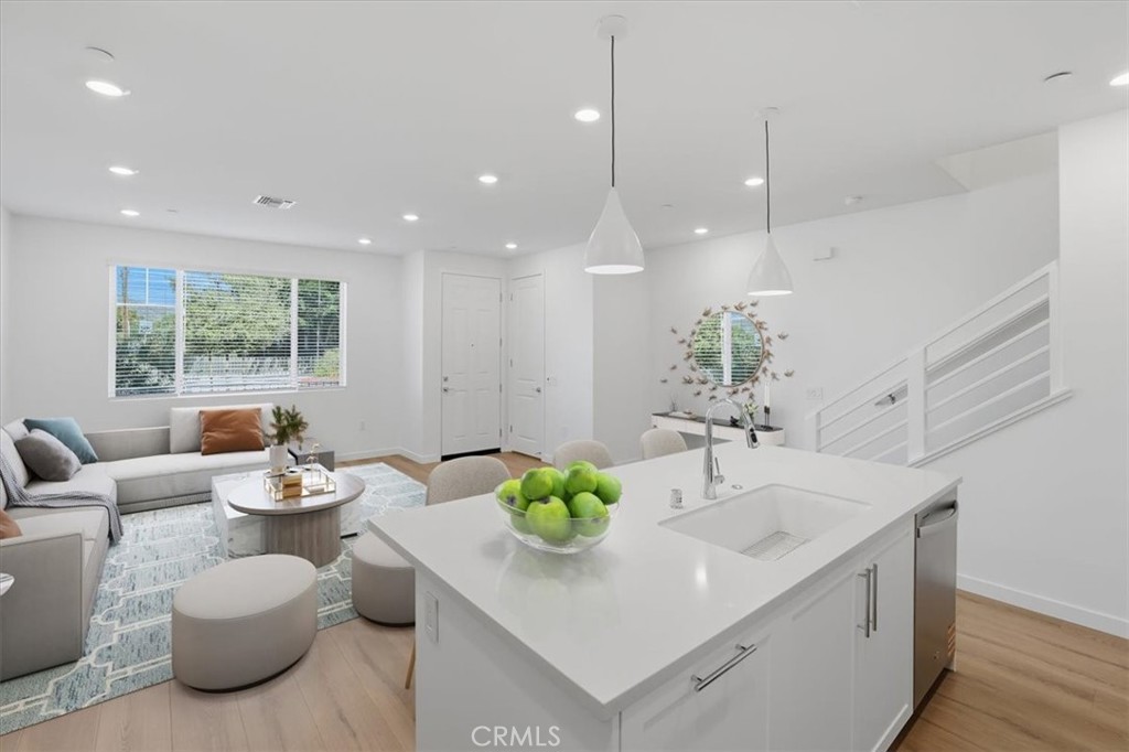 2378 Channel Drive, Unit 103 Ventura, CA 93003 - Photo 11 of 33 a kitchen with stainless steel appliances kitchen island granite countertop a sink and a granite counter tops with white cabinets