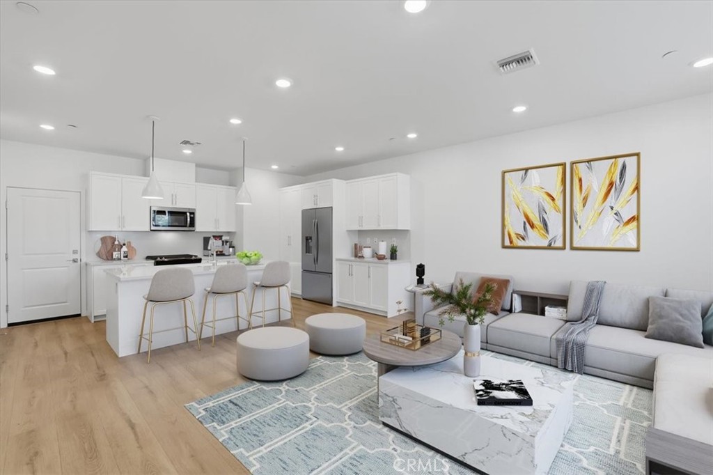 2378 Channel Drive, Unit 103 Ventura, CA 93003 - Photo 5 of 33 a living room with furniture kitchen view and a wooden floor