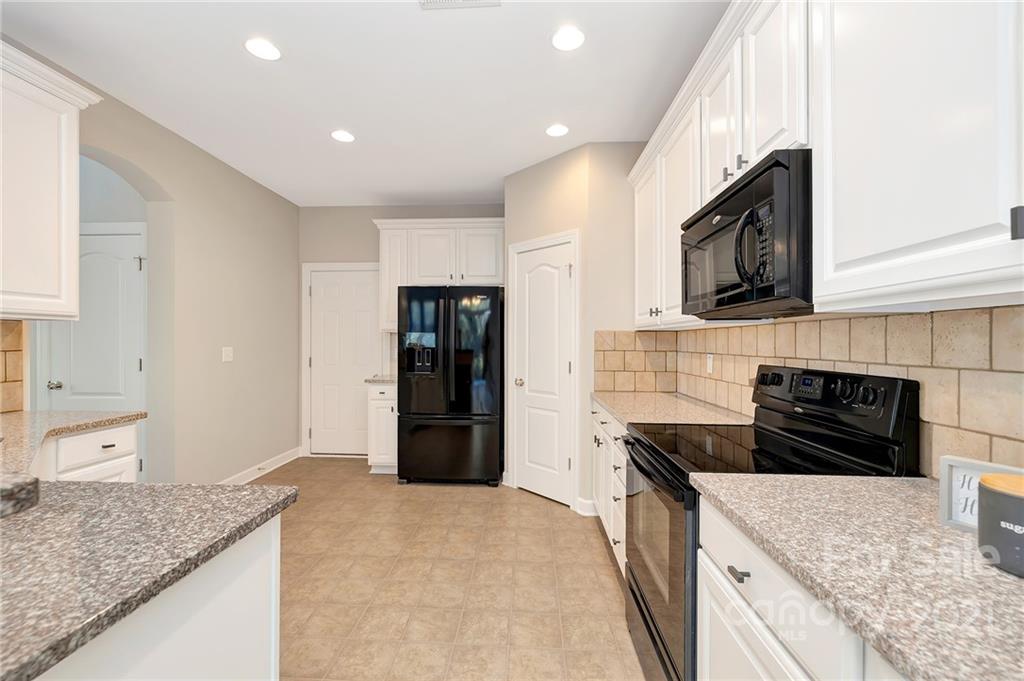 6931 Maricopa Road Charlotte, NC 28277 - Photo 11 of 31 a kitchen with granite countertop a sink and a stove top oven