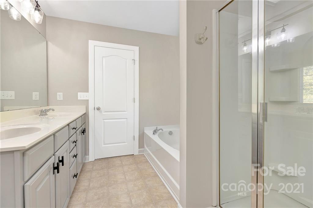 6931 Maricopa Road Charlotte, NC 28277 - Photo 20 of 31 a spacious bathroom with a double vanity sink a mirror and a bathtub