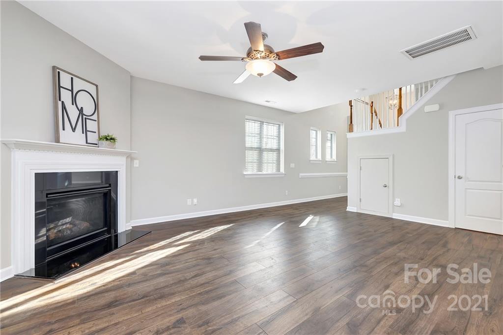 6931 Maricopa Road Charlotte, NC 28277 - Photo 6 of 31 a view of an empty room with wooden floor fireplace and a window