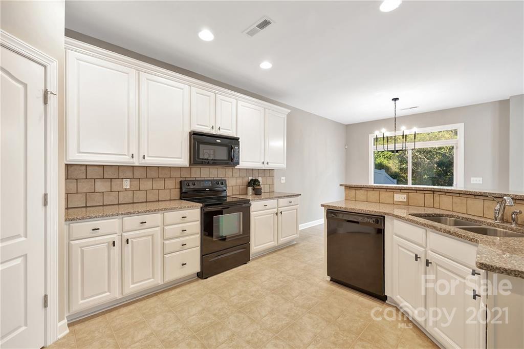 6931 Maricopa Road Charlotte, NC 28277 - Photo 10 of 31 a kitchen with granite countertop white cabinets sink and stainless steel appliances