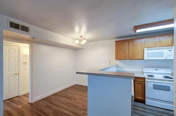 a view of an empty room with wooden floor