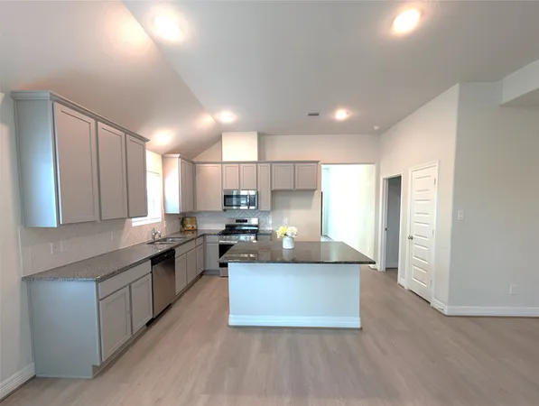 a kitchen with stainless steel appliances granite countertop a stove a sink and a refrigerator