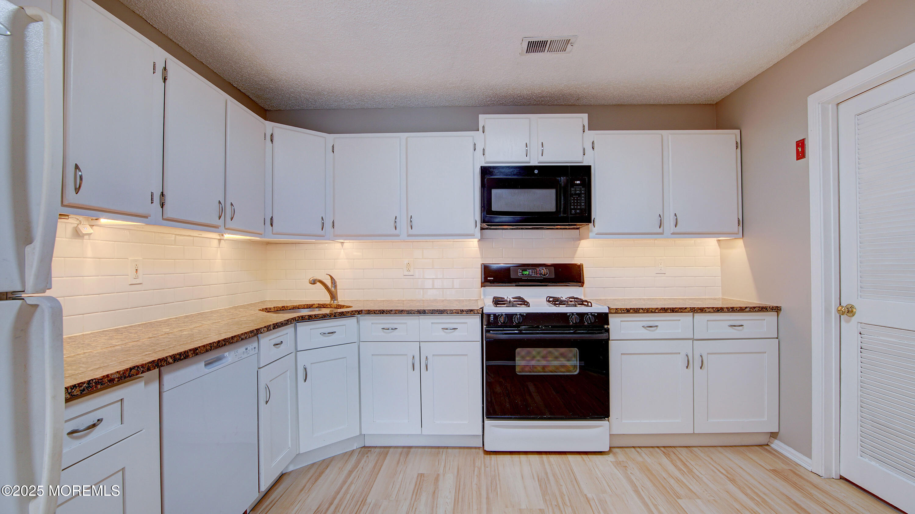 316 Tulip Lane Freehold, NJ 07728 - Photo 16 of 39 a kitchen with granite countertop white cabinets and stainless steel appliances