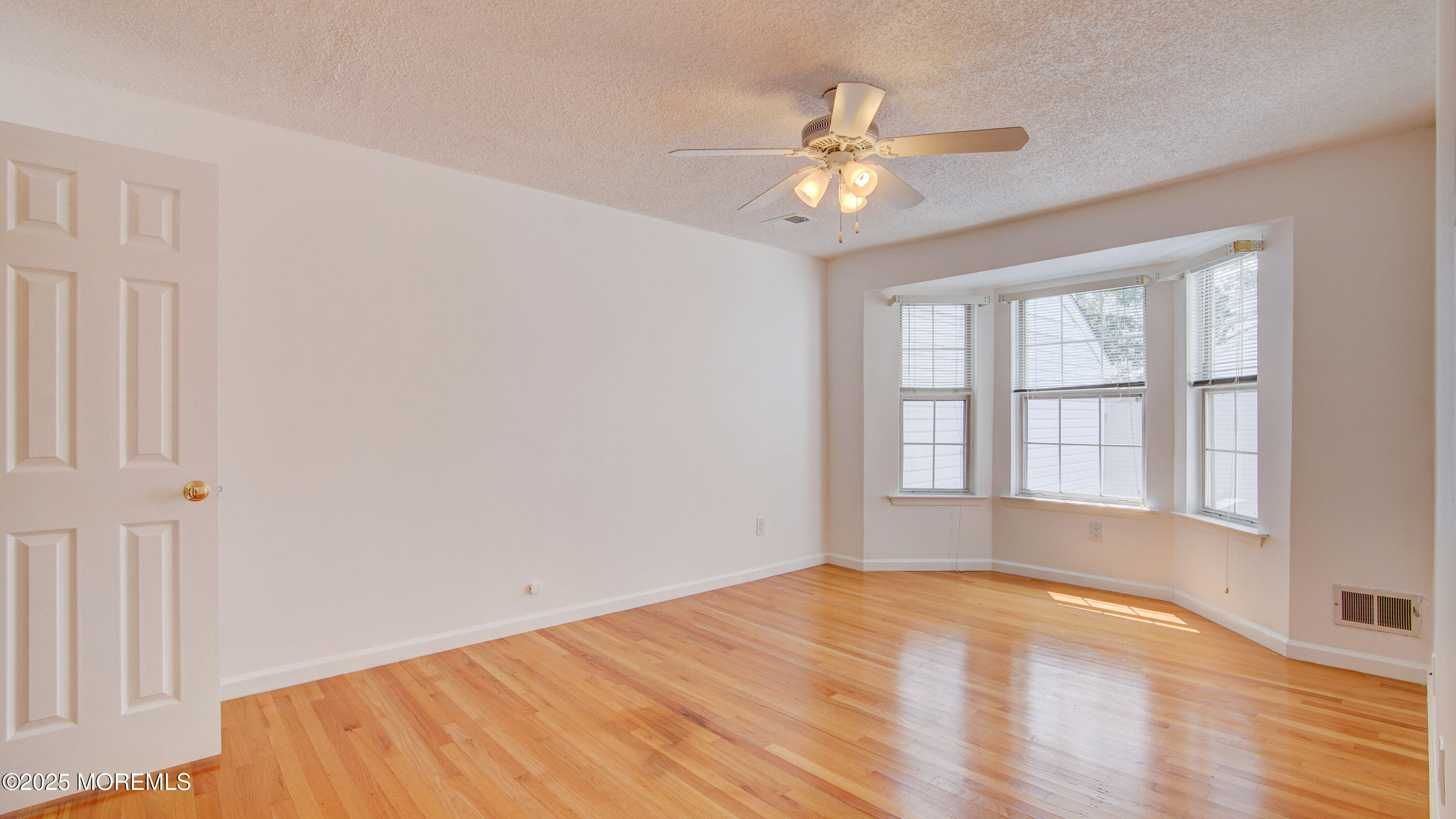 316 Tulip Lane Freehold, NJ 07728 - Photo 23 of 39 a view of an empty room with wooden floor and a window