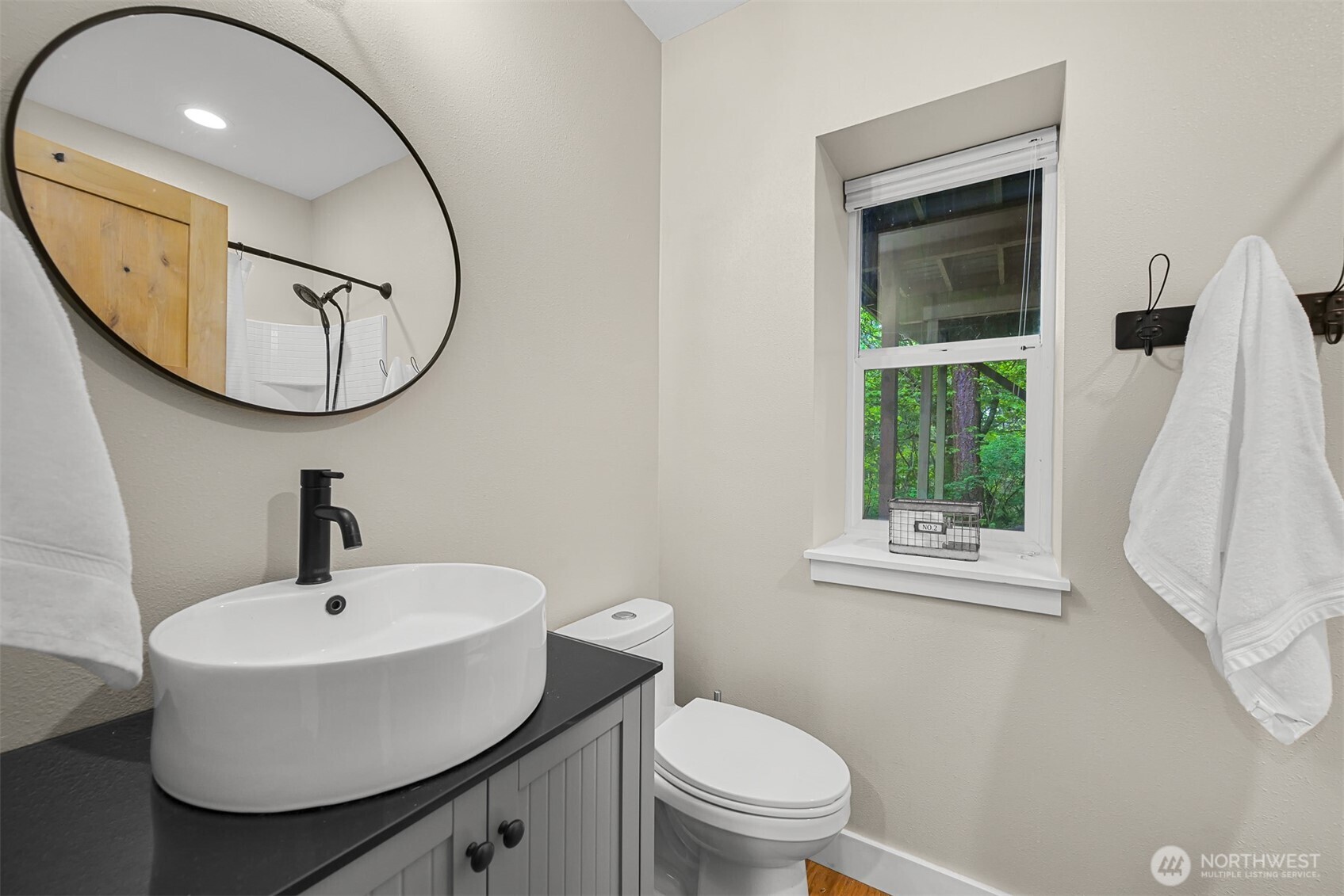 9111 Custer School Road Custer, WA 98240 - Photo 29 of 40 a bathroom with a sink a mirror a toilet and a window