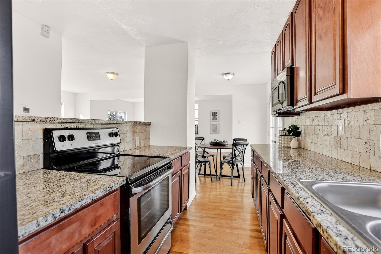 2836 South Grape Way Denver, CO 80222 - Photo 12 of 29 a kitchen with a stove sink and cabinets