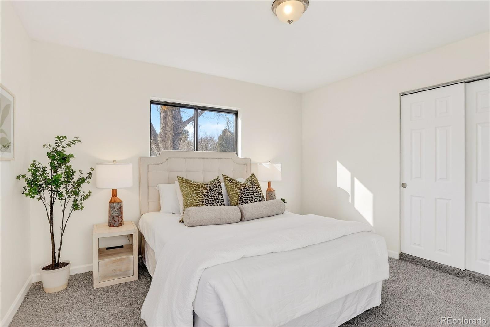 2836 South Grape Way Denver, CO 80222 - Photo 18 of 29 a bedroom with a bed and a potted plant