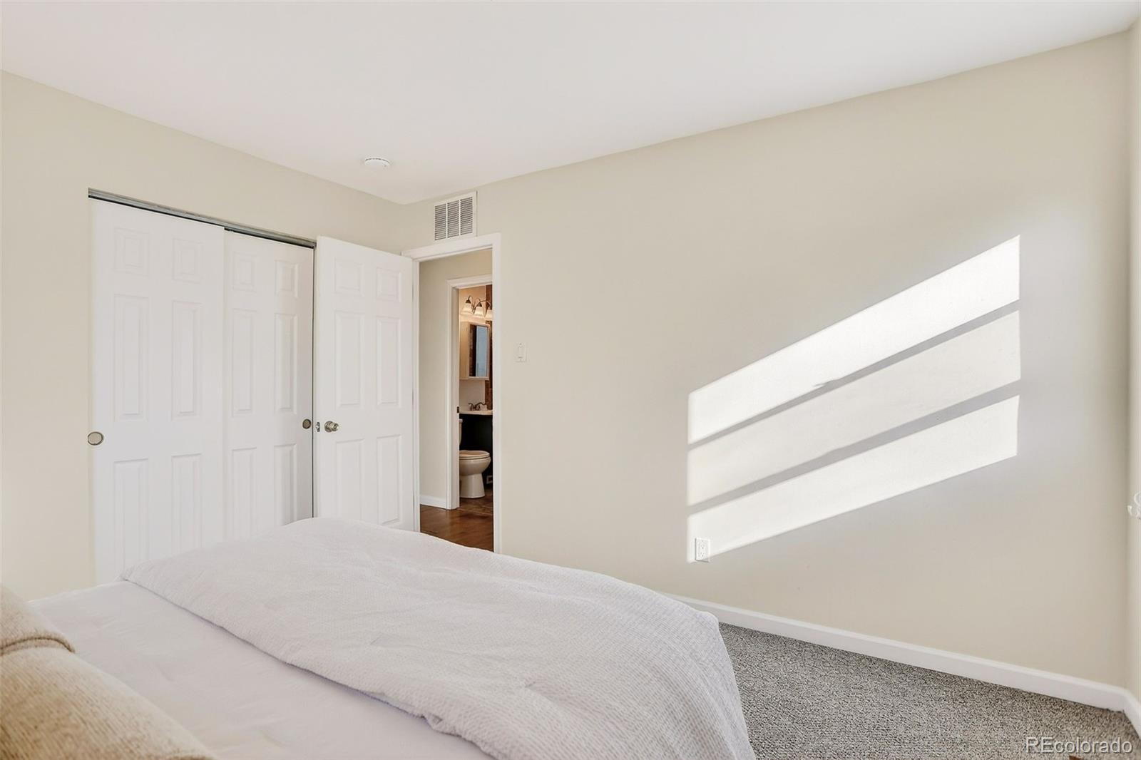 2836 South Grape Way Denver, CO 80222 - Photo 19 of 29 a bedroom with a bed and a window