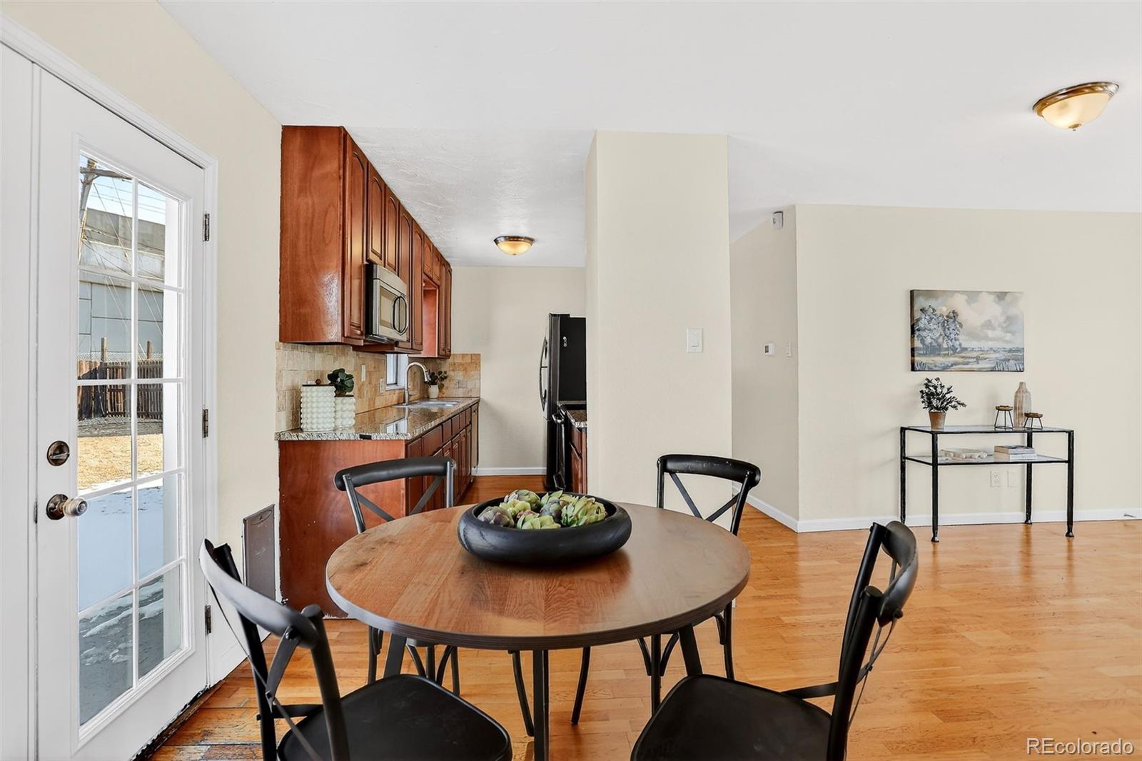 2836 South Grape Way Denver, CO 80222 - Photo 2 of 29 a view of a dining room with furniture and wooden floor