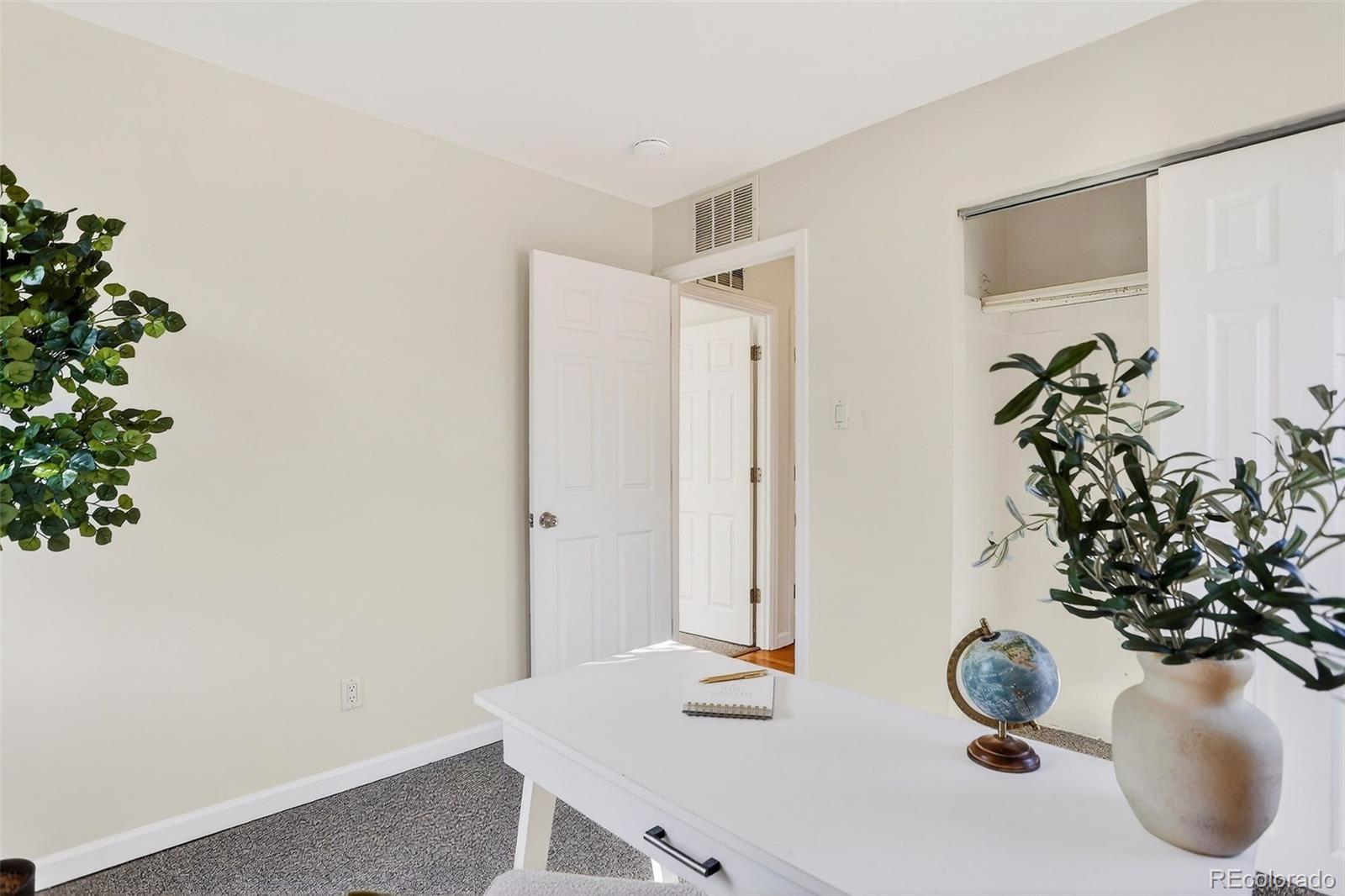 2836 South Grape Way Denver, CO 80222 - Photo 23 of 29 a bathroom with a vase of flowers