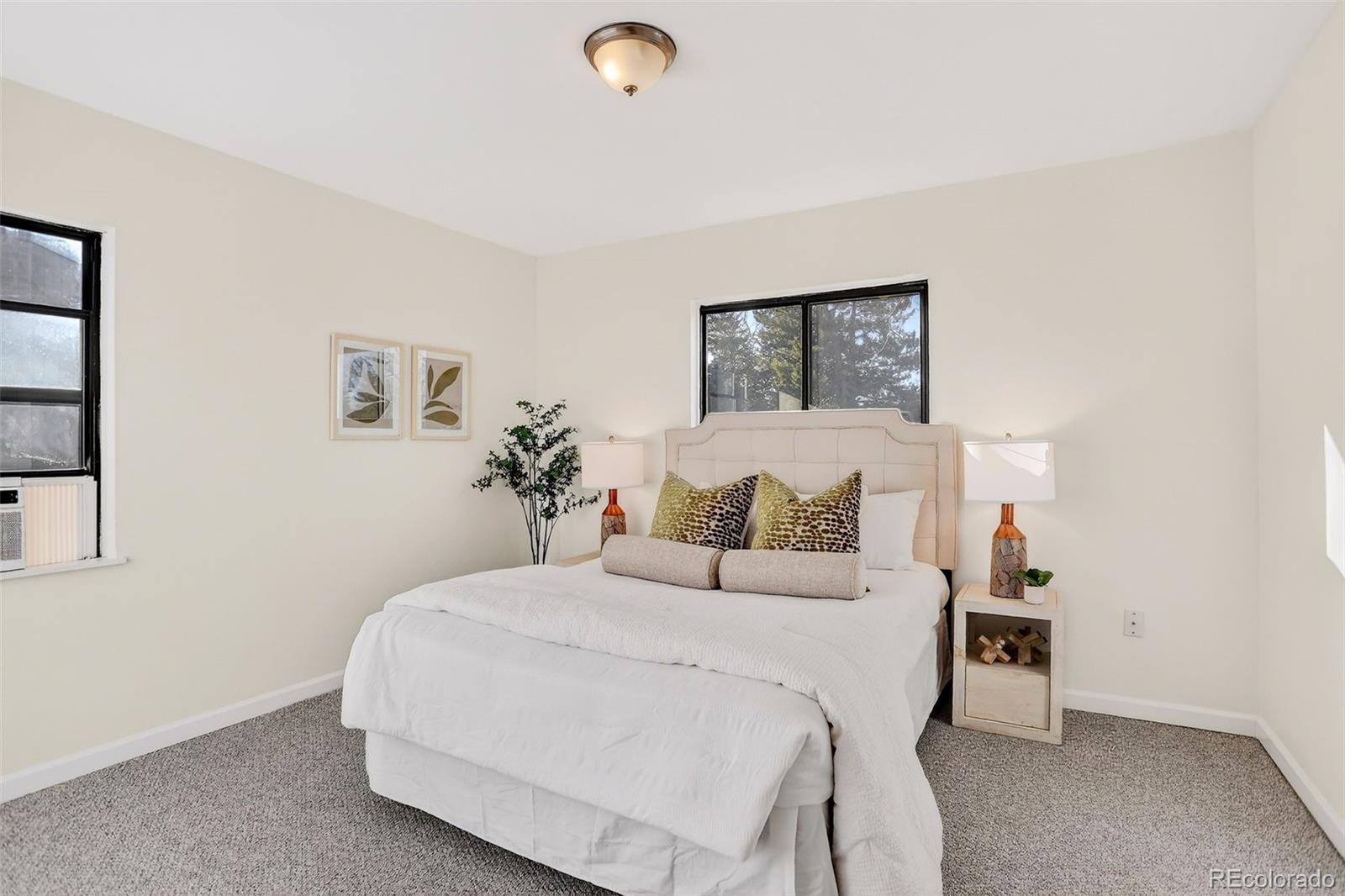 2836 South Grape Way Denver, CO 80222 - Photo 3 of 29 a bedroom with a bed and a lamp on the dresser