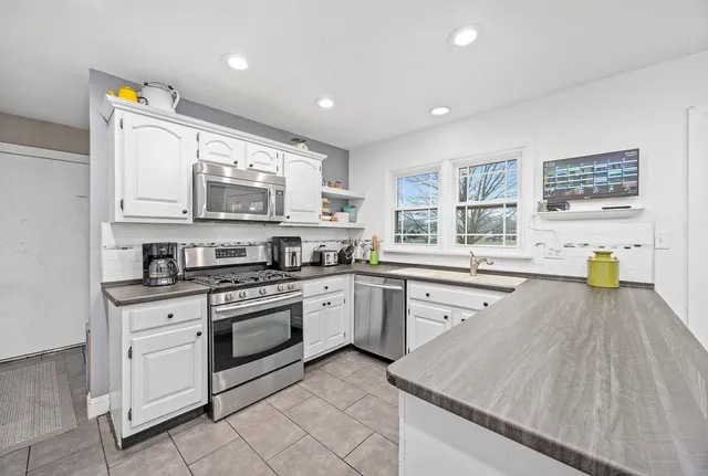 a kitchen with stainless steel appliances granite countertop a stove and a sink