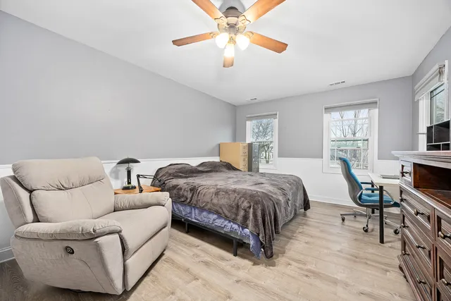 a spacious bedroom with a bed a couch and a chandelier