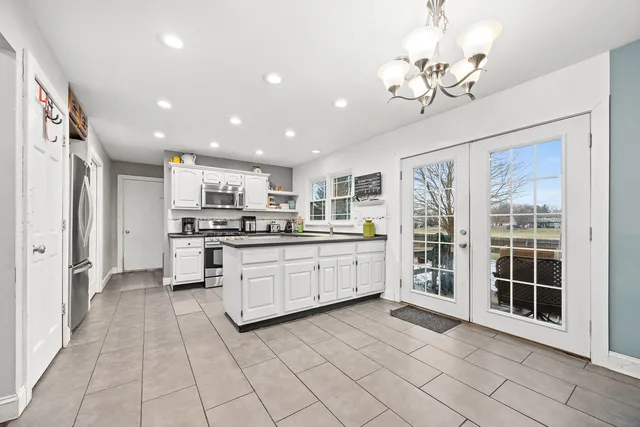a large white kitchen with cabinets