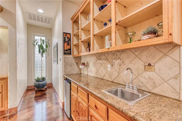 a kitchen with granite countertop a sink and a wooden floor