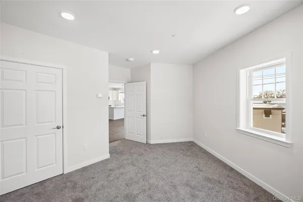 an empty room with a window and a kitchen