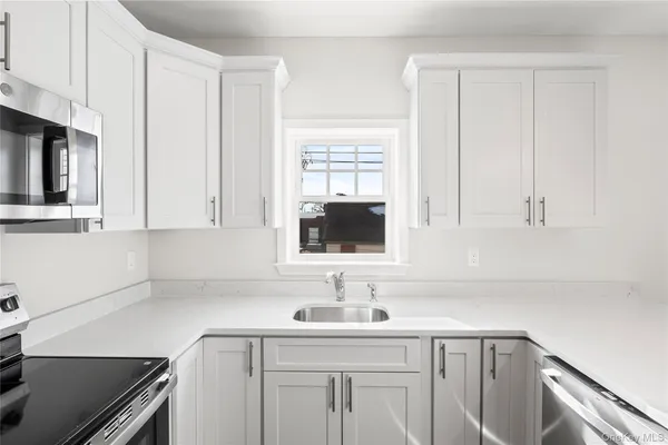 a kitchen with a sink cabinets and window