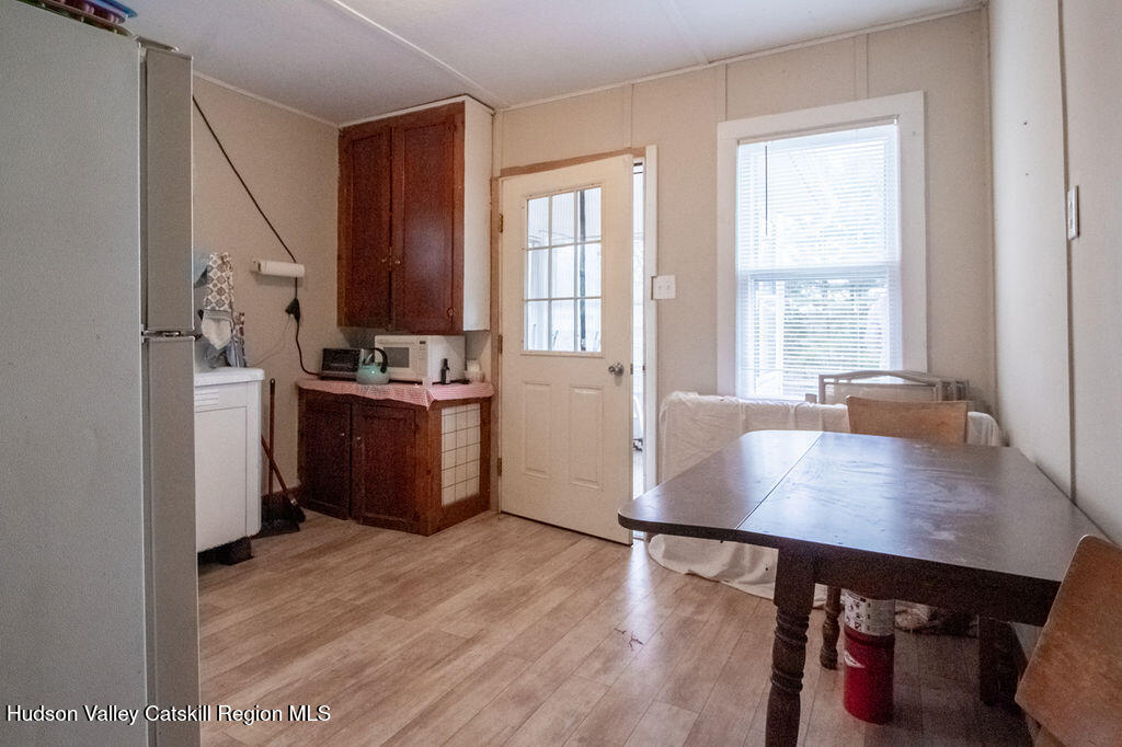 224 Camp Road Ellenville, NY 12428 - Photo 28 of 50 a kitchen with stainless steel appliances a stove a sink a refrigerator white cabinets and wooden floor