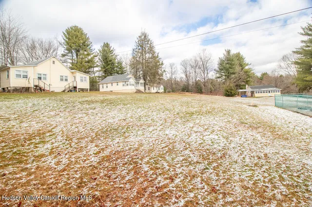 a large white house with a snow on the road