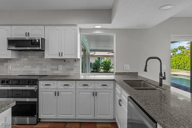 a kitchen with granite countertop a stove and a sink