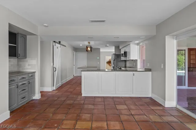 a kitchen with white cabinets and appliances