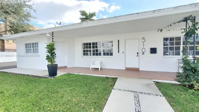 a front view of a house with a yard and trees