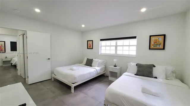 a bedroom with two beds and a window