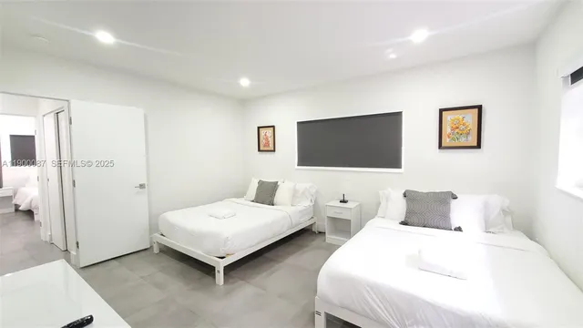 a spacious bedroom with two beds and a flat screen tv