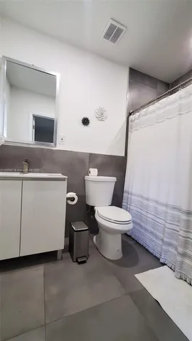 a white toilet sitting next to a bathroom sink