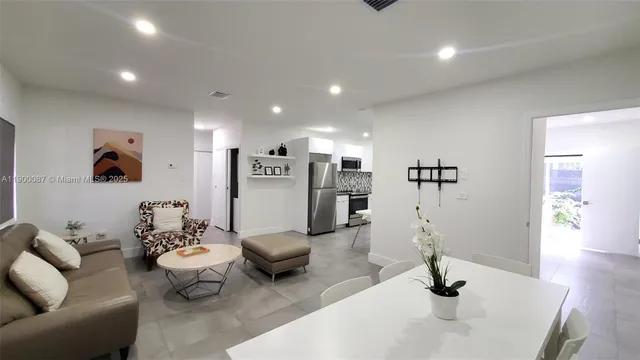 a living room with lots of furniture and view of kitchen
