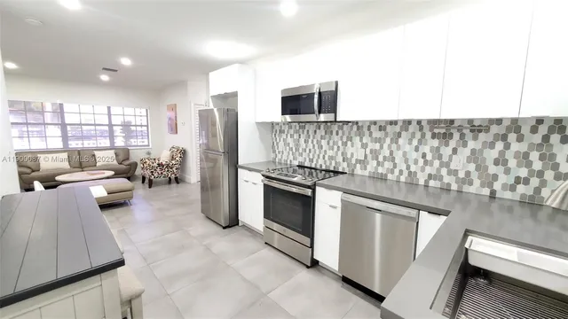 a kitchen with stainless steel appliances granite countertop a stove and a sink