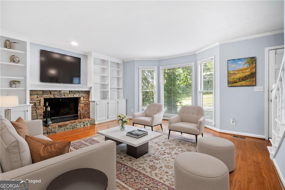661 North Parkwood Road Decatur, GA 30030 - Photo 2 of 13 Living room with light hardwood / wood-style floors, crown molding, a fireplace, and built in shelves