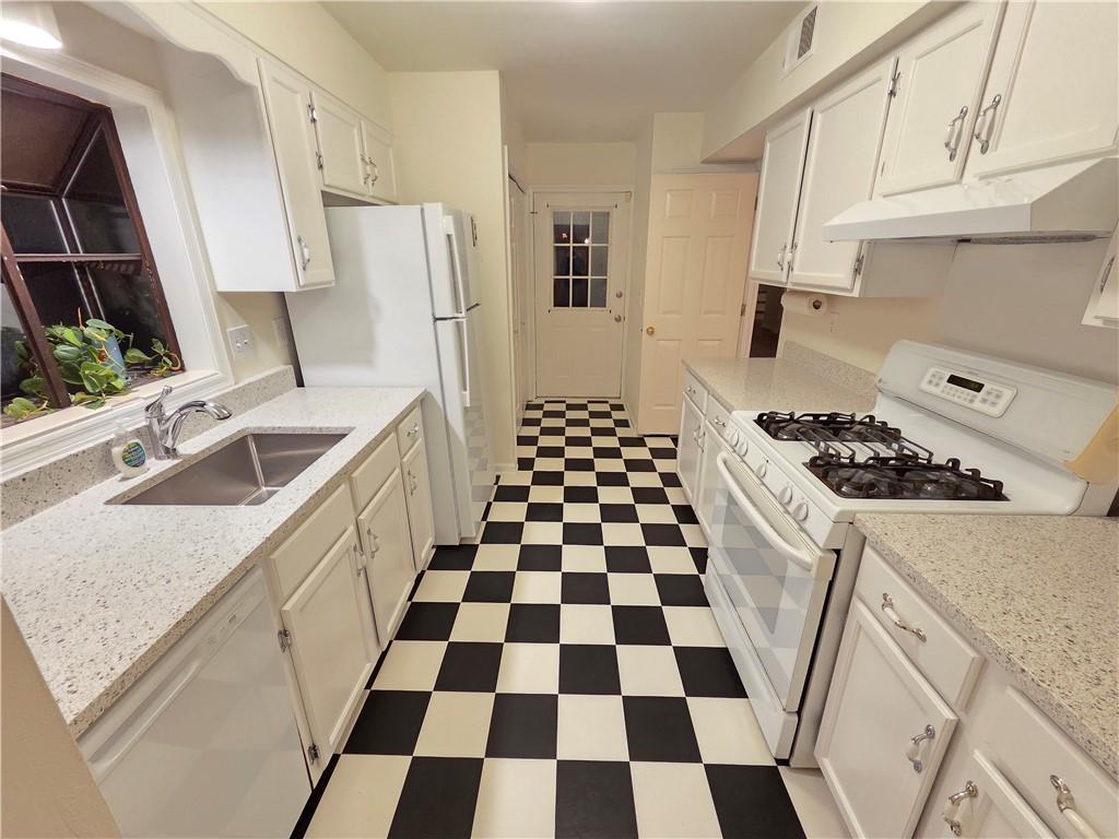 8 Old Decatur Circle Decatur, GA 30030 - Photo 7 of 27 a kitchen with a checkered floor and white cabinets