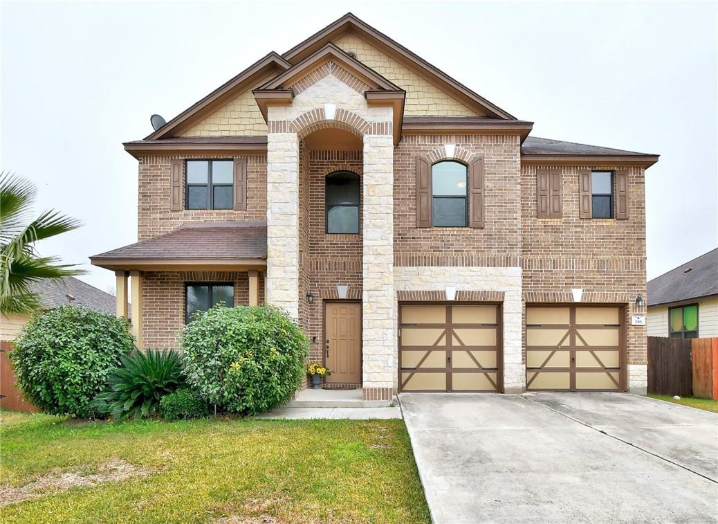 A classic brick two-story residence features a stone-accented facade and inviting front entry.