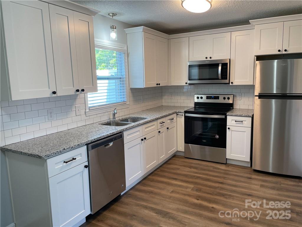 4581 County Home Road, Unit 1 Conover, NC 28613 - Photo 3 of 10 a kitchen with stainless steel appliances granite countertop a stove a sink and a refrigerator