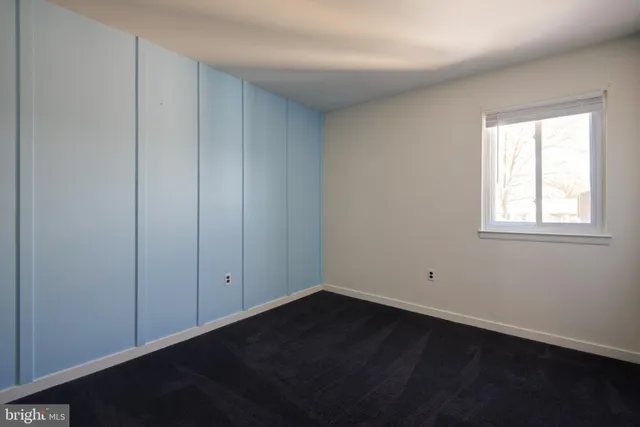 an empty room with wooden floor and closet area