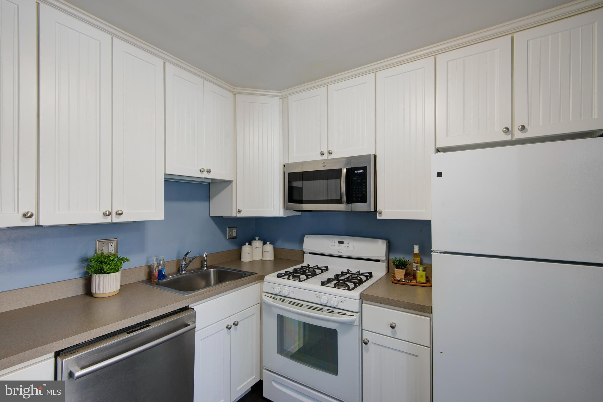1210 Painters Crossing, Unit 1210 Chadds Ford, PA 19317 - Photo 7 of 18 a kitchen with stainless steel appliances granite countertop white cabinets sink and a stove
