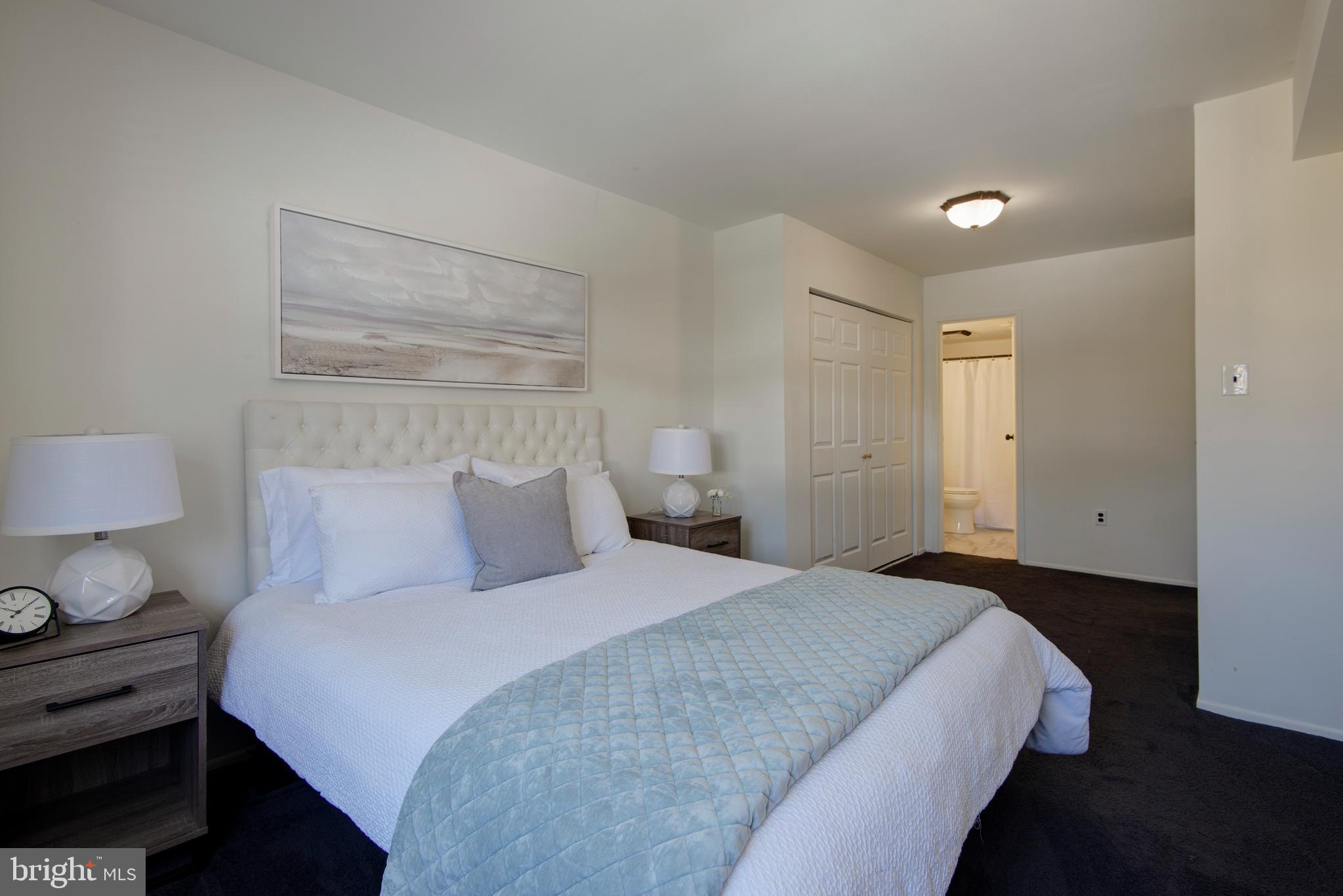 1210 Painters Crossing, Unit 1210 Chadds Ford, PA 19317 - Photo 10 of 18 a bedroom with a bed and a night stand