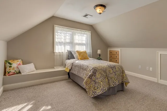 a spacious bedroom with a bed and a window